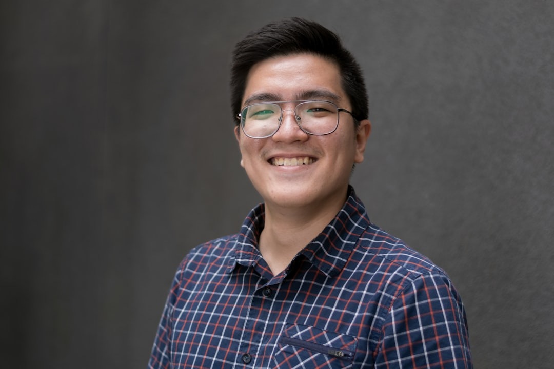 a man with glasses smiling for the camera